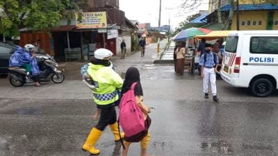 Terlihat Kasat Lantas Polres Dumai gendong satu pelajar Sekolah (foto/Istimewa).