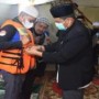 Teks foto : Bupati Bengkalis mewakili Asisten Pemerintahan dan Kesejahteraan Rakyat Andris Wasono memasang life jacket kepeserta Sholawat Beghanyut (18/12/21) malam (foto/Indra).