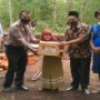 Teks foto : Kasi Humas Polres Bengkalis AKP Buha Purba, SH, didampingi Fadli Ketua AJOI serahkan bantu ke Nenek Nuraini (foto/Indra).