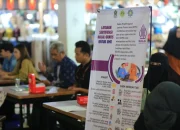 Kategori: Bisnis Kata Kunci Utama: Sertifikasi Halal Judul (Headline): Jelang Wajib Halal Oktober 2026, Ratusan UMKM Bengkalis Didorong Segera Urus Sertifikasi Halal Judul SEO: UMKM Bengkalis Didorong Urus Sertifikasi Halal 2026 Slug: umkm-bengkalis-sertifikasi-halal-2026 Meta Deskripsi: BPJPH mengedukasi ratusan pelaku UMKM di Bengkalis terkait sertifikasi halal menjelang penerapan Wajib Halal Oktober 2026. Isi Artikel: Rakyat45.com, Bengkalis – Ratusan pelaku Usaha Mikro, Kecil, dan Menengah (UMKM) di Kabupaten Bengkalis mendapatkan sosialisasi terkait sertifikasi halal menjelang penerapan kebijakan Wajib Halal Oktober (WHO) 2026 yang akan berlaku mulai 18 Oktober 2026. Kegiatan yang digelar oleh Badan Penyelenggara Jaminan Produk Halal tersebut menyasar pedagang Pasar Terubuk, pedagang kaki lima, serta pelaku usaha di sejumlah titik strategis di Kabupaten Bengkalis. Program Wajib Halal Oktober 2026 merupakan implementasi dari Undang-Undang Nomor 33 Tahun 2014 dan Peraturan Pemerintah Nomor 42 Tahun 2024 yang mengatur kewajiban sertifikasi halal bagi produk tertentu yang beredar di Indonesia. Pengawas BPJPH Kabupaten Bengkalis, Hafizha Mawaddah, mengatakan sosialisasi tersebut merupakan bagian dari gerakan nasional yang dilaksanakan secara serentak di ribuan lokasi di seluruh Indonesia. "Di Riau sosialisasi dilaksanakan di 38 titik. Sedangkan di Bengkalis, kegiatan ini menyasar masyarakat dan pelaku usaha pada tiga lokasi strategis, yakni pedagang lapangan Pasir Andam Dewi, Pasar Terubuk, dan Pelabuhan Roro Bengkalis," jelasnya, Sabtu (6/6/2026). Menurut Hafizha, sertifikasi halal tidak hanya menjadi kewajiban regulasi, tetapi juga memberikan manfaat ekonomi bagi pelaku usaha. Produk yang telah bersertifikat halal dinilai memiliki daya saing lebih tinggi karena mampu meningkatkan kepercayaan konsumen. Dalam pelaksanaannya, BPJPH menggandeng berbagai pihak, termasuk perwakilan LP3H Mathlaul Anwar serta para Pendamping Proses Produk Halal (P3H) untuk memberikan edukasi kepada masyarakat dan pelaku usaha. "Pada intinya, ini bertujuan agar para pelaku usaha tidak hanya memahami kewajiban hukum yang akan berlaku, tetapi juga melihat sertifikasi halal sebagai nilai tambah yang mampu meningkatkan kepercayaan konsumen terhadap produk yang dipasarkan," sebutnya kepada Rakyat45.com, Sabtu (6/6/2026). Pemerintah menilai kewajiban sertifikasi halal merupakan bentuk perlindungan kepada masyarakat dalam memastikan produk yang dikonsumsi atau digunakan telah memenuhi standar kehalalan yang ditetapkan. Selain memberikan kepastian, keamanan, dan kenyamanan bagi konsumen, kebijakan tersebut juga diharapkan dapat mendorong pengembangan usaha serta memperluas peluang pasar bagi pelaku UMKM di daerah. Melalui sosialisasi yang terus digencarkan menjelang Oktober 2026, BPJPH berharap semakin banyak pelaku usaha yang segera mengurus sertifikasi halal sehingga siap menghadapi implementasi penuh kebijakan Wajib Halal Oktober 2026.*** Tag: Sertifikasi Halal, BPJPH, UMKM Bengkalis, Wajib Halal Oktober 2026, Produk Halal Indonesia